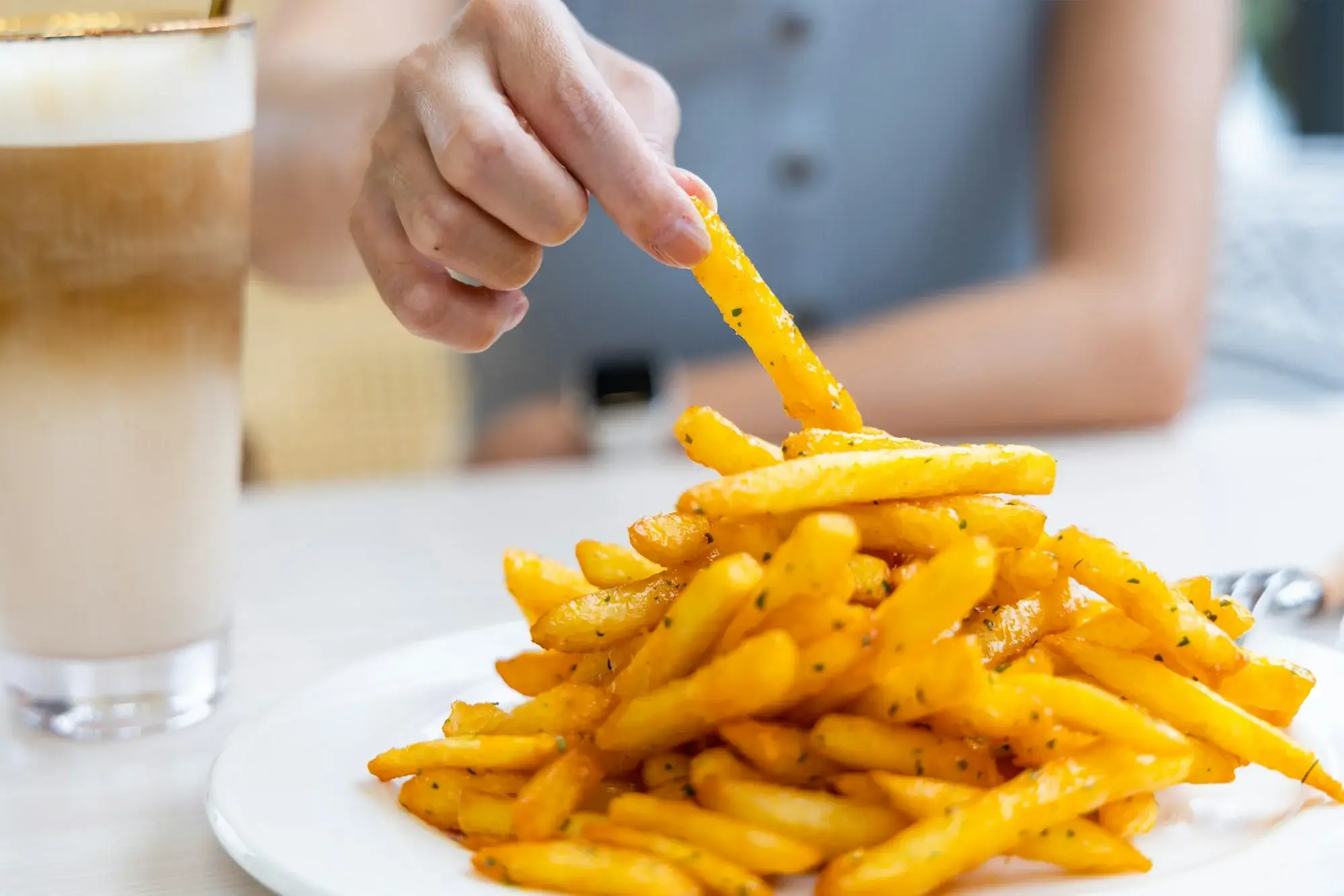 Verse friet in airfryer goudbruin en knapperig op een bord.